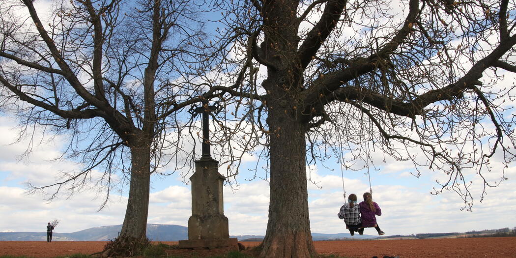 Houpačka u kříže mezi lány