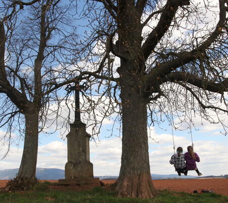 Houpačka u kříže mezi lány